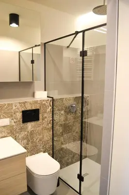 a bathroom with a toilet and a glass shower at Tutu Kraków in Kraków
