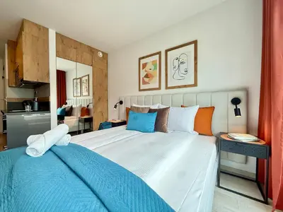 a bedroom with a large bed with blue and orange pillows at PANORAMA VIEW by MINT APARTMENT in Kraków