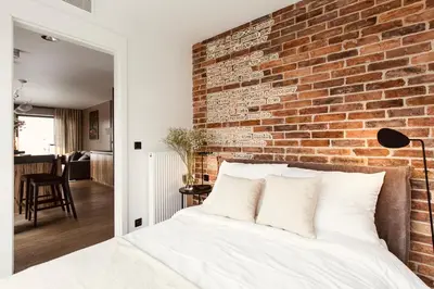 a bedroom with a brick wall and a bed at PANORAMA VIEW by MINT APARTMENT in Kraków