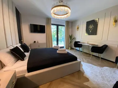 a bedroom with a large bed and a chandelier at Lux Stays by Torres at K39 Krakow in Kraków