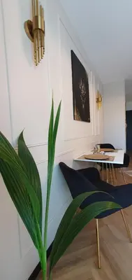 a living room with a potted plant and a table at Lux Stays by Torres at K39 Krakow in Kraków