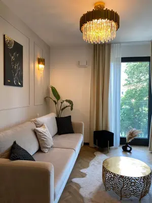a living room with a couch and a chandelier at Lux Stays by Torres at K39 Krakow in Kraków