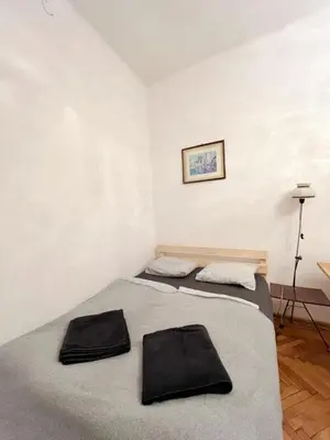 two beds in a room with white walls at Cozy studio in Cracow in Kraków