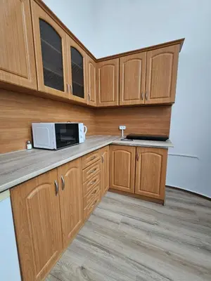 a kitchen with wooden cabinets and a microwave at Cozy studio in Cracow in Kraków
