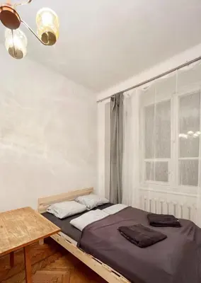 a bedroom with a bed and a table and a window at Cozy studio in Cracow in Kraków