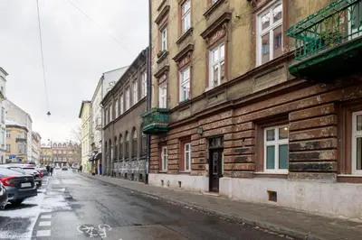 an old building on a city street with cars parked at Bocheńska 6 by Homeprime in Kraków