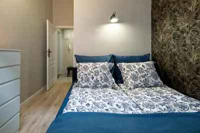 a bedroom with a bed with blue sheets and pillows at Bocheńska 6 by Homeprime in Kraków