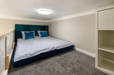 a bedroom with a large bed with blue pillows at Bocheńska 6 by Homeprime in Kraków