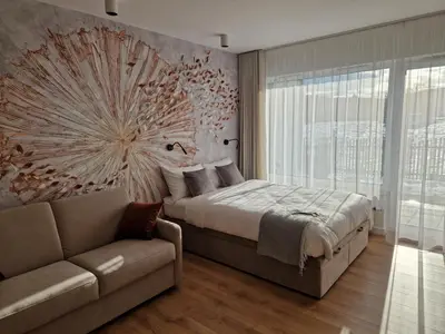 a bedroom with a bed and a couch at Apartament Sunray in Kraków