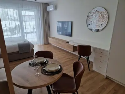 a room with a table and chairs and a bed at Apartament Sunray in Kraków