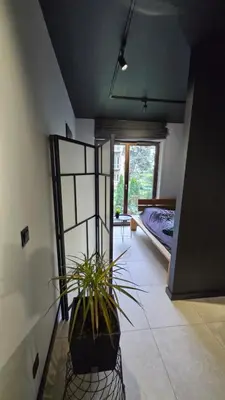 a room with a potted plant and a bedroom at Design Vistula old town apartment private underground parking in Kraków