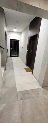 an empty hallway with a tile floor and black doors at Design Vistula old town apartment private underground parking in Kraków