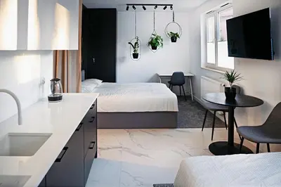 a bedroom with two beds and a kitchen with a sink at UR4N Apartment - Heltmana in Kraków