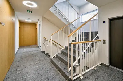 an empty hallway with stairs in a building at UR4N Apartment - Heltmana in Kraków