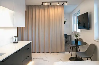 a kitchen with a small table and a window at UR4N Apartment - Heltmana in Kraków