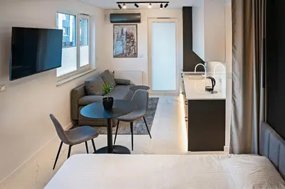 a small living room with a bed and a kitchen at UR4N Apartment - Heltmana in Kraków