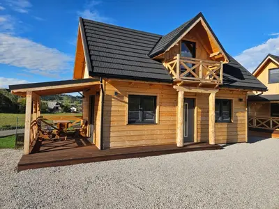 a log cabin with a porch and a deck at beskid.house2 in Spytkowice