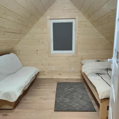 two beds in a small room with a window at beskid.house2 in Spytkowice