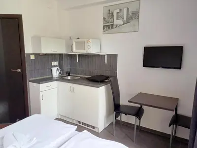 a small kitchen with a table and a microwave at Willa na Bani - apartamenty i pokoje in Rabka