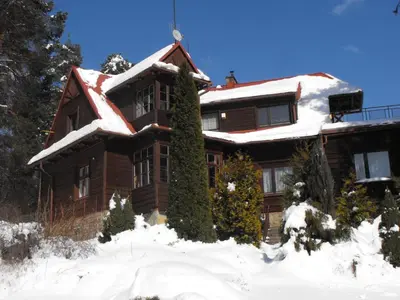 a house with snow on the roof at Willa na Bani - apartamenty i pokoje in Rabka