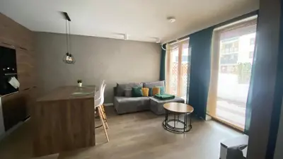 a living room with a table and a couch at Apartament Złocień in Kraków