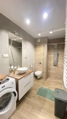 a bathroom with a washing machine and a toilet at Apartament Złocień in Kraków
