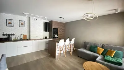 a kitchen and living room with a couch and chairs at Apartament Złocień in Kraków