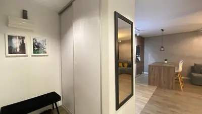 a room with a mirror and a living room at Apartament Złocień in Kraków