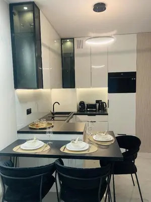 a kitchen with a table and chairs with plates and glasses at Crystal Luxury Apartment with Free Parking in Cracow for 4 Guests in Kraków