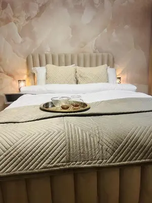 a bed with a tray with two glasses on it at Crystal Luxury Apartment with Free Parking in Cracow for 4 Guests in Kraków
