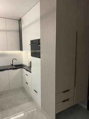 a kitchen with white cabinets and a sink and a refrigerator at Crystal Luxury Apartment with Free Parking in Cracow for 4 Guests in Kraków