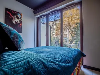 a bedroom with a bed and a large window at Loft vistula old town apartament free parking in Kraków