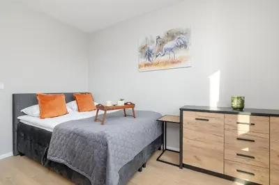 a bedroom with a bed and a dresser at Bright Apartment Park Lotników Near Tauron Arena Kraków by Noclegi Renters in Kraków