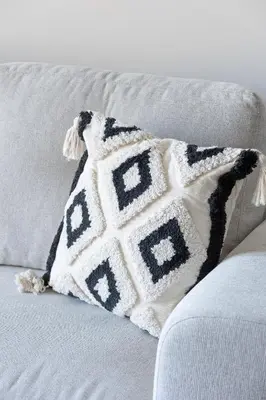 a black and white pillow on a couch at Bright Apartment Park Lotników Near Tauron Arena Kraków by Noclegi Renters in Kraków