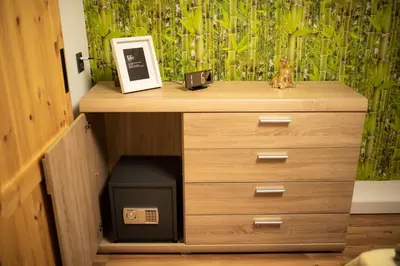 a wooden dresser with a clock on top of it at Apartament 33 Skawina in Skawina