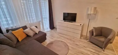 a living room with a couch and a chair and a television at Apartament Sołtysowska 10d NEAR Tauron Arena, EXPO in Kraków