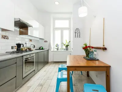 a kitchen with a wooden table and blue stools at Apartament przy Wawelu 80 m2 6 osób Kazimierz in Kraków