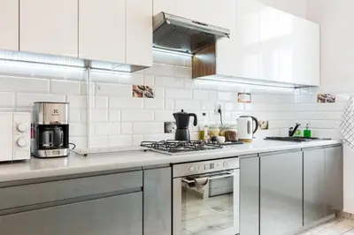 a kitchen with stainless steel appliances and white tiles at Apartament przy Wawelu 80 m2 6 osób Kazimierz in Kraków