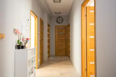 a hallway with a door and a clock on the wall at Apartament przy Wawelu 80 m2 6 osób Kazimierz in Kraków