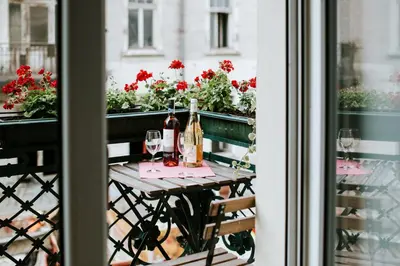 a table with wine bottles and glasses on a balcony at Apartament przy Wawelu 80 m2 6 osób Kazimierz in Kraków