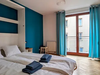 a bedroom with blue walls and a bed with two towels on it at Karłowicza 12 by Homeprime in Kraków