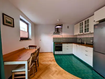 a kitchen with a wooden table and a refrigerator at Karłowicza 12 by Homeprime in Kraków