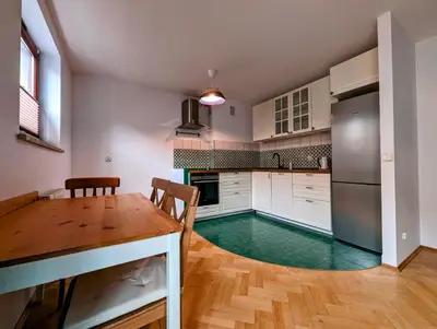 a kitchen with a wooden table and a refrigerator at Karłowicza 12 by Homeprime in Kraków