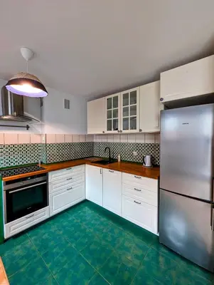 a kitchen with white cabinets and a green floor at Karłowicza 12 by Homeprime in Kraków