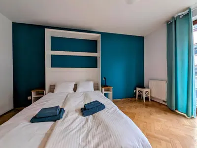 a bedroom with a large white bed with blue walls at Karłowicza 12 by Homeprime in Kraków