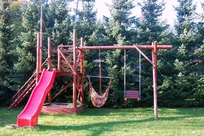 a playground with a slide and a swing at Dom Gościnny E-Lufka in Zawoja