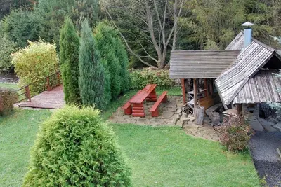 a garden with a bench and a wooden bridge at Dom Gościnny E-Lufka in Zawoja