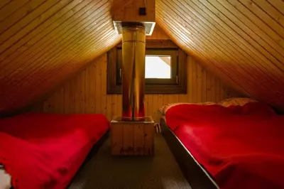 a attic room with two beds and a heater at Dom Gościnny E-Lufka in Zawoja