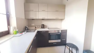 a kitchen with black and white appliances and a chair at Przemysłowa 4 by Homeprime in Kraków
