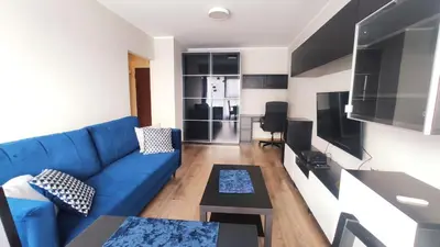 a living room with a blue couch and a table at Przemysłowa 4 by Homeprime in Kraków